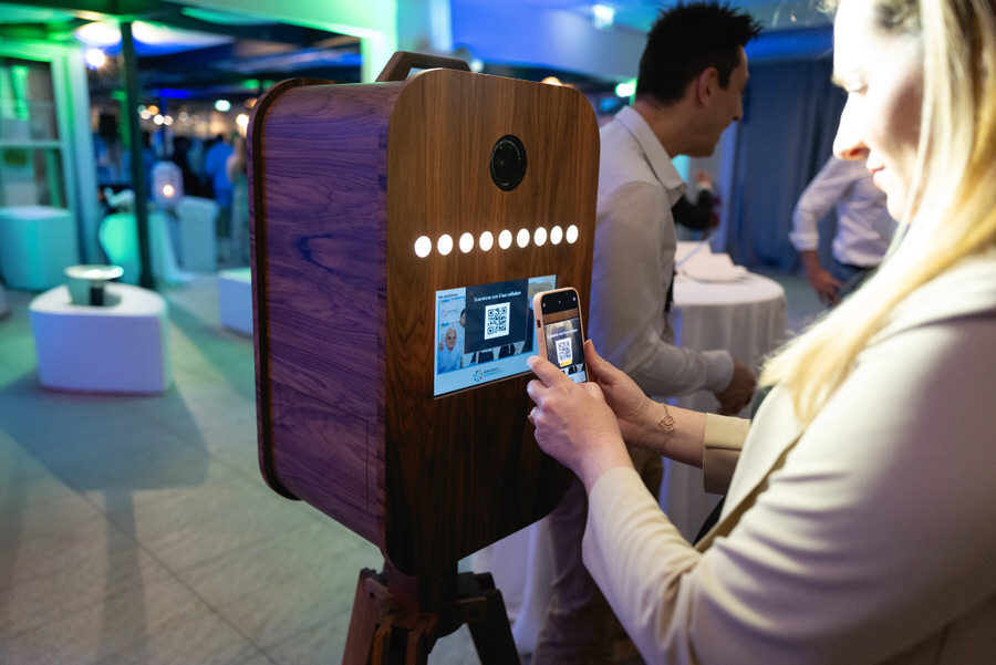 Fotobox aziendale interattivo con touchscreen e condivisione istantanea su social media.