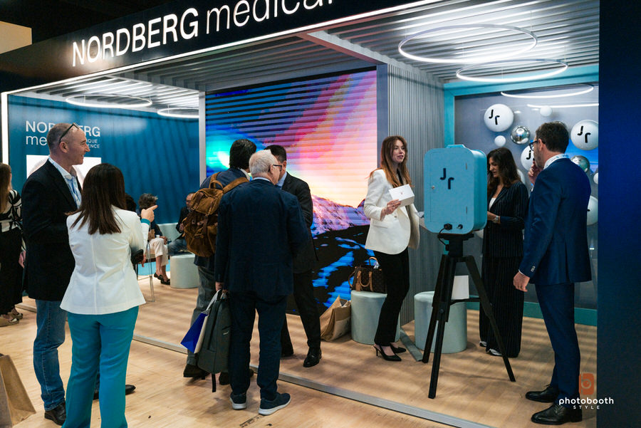 Panoramica stand aziendale con photobooth e partecipanti all’evento